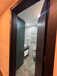 a bathroom with a door open to a bathroom with a sink at Apartment Beach in Itʼkhvisi