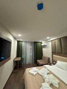 a hotel room with a bed and a chair and a television at Apartment Beach in Itʼkhvisi