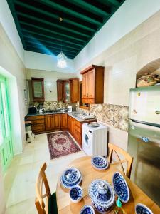 a kitchen with a table with blue and white plates on it at Maison Céline in Sousse