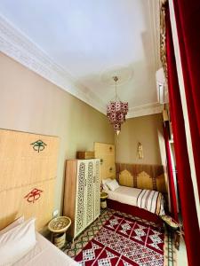 a room with two beds and a chandelier at Maison Céline in Sousse