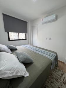 a bedroom with two beds with pillows and a window at Lunar Prime Aruana in Aracaju +12 photos