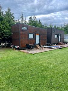a tiny house sitting on top of a grass field at Domek Surf Camp in Jastarnia