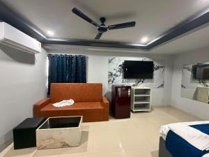 a living room with a couch and a tv at HOTELc3 in Visakhapatnam