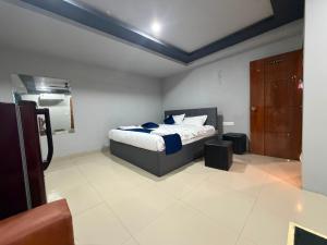 a bedroom with a bed and a brown cabinet at HOTELc3 in Visakhapatnam +4 photos