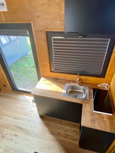a kitchen with a sink and a window at Domek Surf Camp in Jastarnia +3 photos