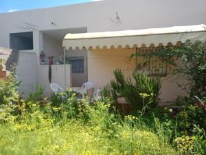 a house with a table and chairs in the yard at Dar Si Lamin 2 in Kelibia +2 photos