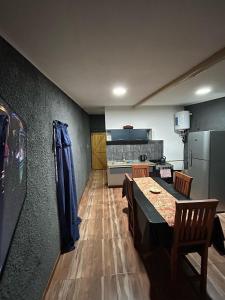 a kitchen with a dining table and a refrigerator at EstadiaMalargue in Malargüe