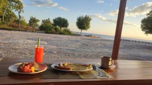 a table with two plates of food and a drink at FURUSATO BUNGALOW Gili Gede in Gili Gede