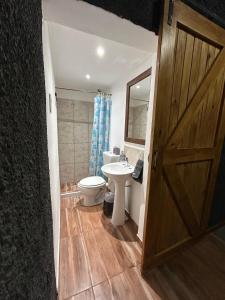 a bathroom with a toilet and a sink and a door at EstadiaMalargue in Malargüe