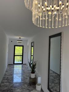 a hallway with a mirror and a chandelier at Millennium Guest House in Kŭrdzhali