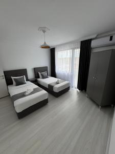 a hotel room with two beds and a window at Millennium Guest House in Kŭrdzhali