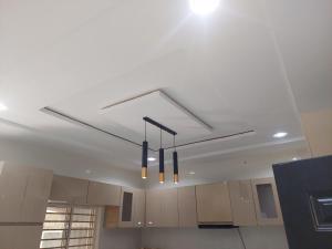 a kitchen with three lights hanging from the ceiling at Nikk home in Ado Ekiti