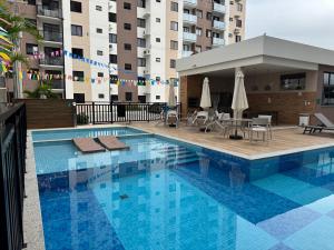 a swimming pool with chairs and umbrellas on a building at Lunar Prime Aruana in Aracaju