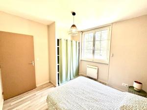 a bedroom with a bed and a large window at La Rivière Enchantée in Peyraud