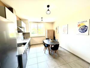 a kitchen with a table and a small table and chairs at La Rivière Enchantée in Peyraud +6 photos