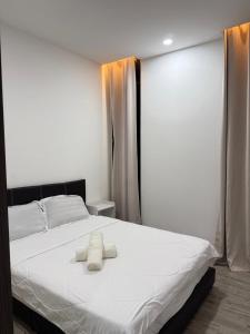 a bedroom with a bed with two towels on it at Podium aparment in Kuching +8 photos