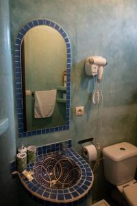 a bathroom with a sink with a mirror and a toilet at Casa Bellavista Chaouen in Chefchaouen