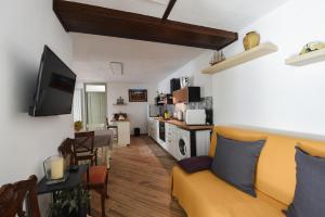 a living room with a yellow couch and a kitchen at Casa Vacanza La Torre in Paratico