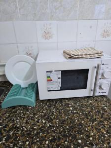 a microwave sitting on top of a counter with a bowl at Italia apart departamentos por día con cochera opcional in Corrientes +52 photos