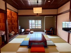 a living room with a table and a tv at なごらーれ放生津屋 in Shimminato