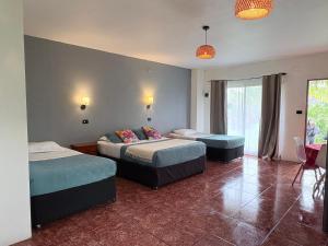 a bedroom with two beds and two ottomans at Cabañas Honu Nui Inn in Hanga Roa
