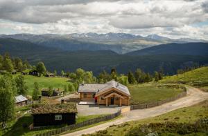a house on a hill with mountains in the background at Hylja Lodge in Vaga