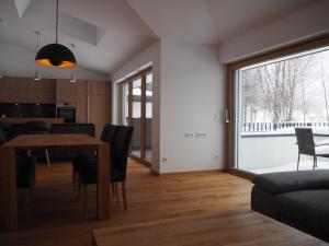 a dining room and living room with a table and chairs at Apartment Smaragdblick Wildkogel in Bramberg am Wildkogel