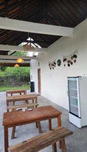 a group of wooden picnic tables in a room at Nora Cottage Natural in Batununggul