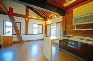 a large kitchen with wooden walls and a staircase at Jeonju Hanok Agbae in Jeonju