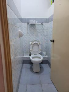 a bathroom with a toilet with the lid up at Greatwall Apartment in Syokimau