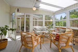 a screened in porch with a table and chairs at SL364-Slagelse-Hirsevangen-4 in Strandlyst