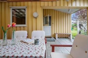 a patio with a table and chairs and a bench at SL365-Rude-Vejrovej-1 in Bisserup Strand +18 photos