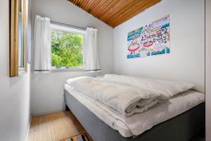 a large bed in a room with a window at SL365-Rude-Vejrovej-1 in Bisserup Strand