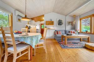 a dining room and living room with a table and chairs at SL365-Rude-Vejrovej-1 in Bisserup Strand