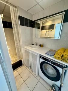a bathroom with a washing machine and a sink at The Rave in Sète