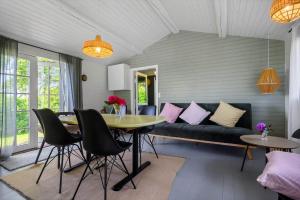 a living room with a couch and a table and chairs at SL369-Rude-Hvirvilsvej-4 in Bisserup
