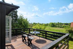 a wooden deck with a table and a bench on it at SL369-Rude-Hvirvilsvej-4 in Bisserup