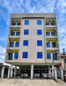 a tall apartment building with blue windows at BJ House in Douala