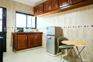 a kitchen with a small table and a refrigerator at BJ House in Douala