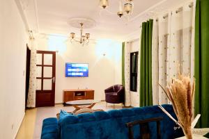 a living room with a blue couch and a table at BJ House in Douala