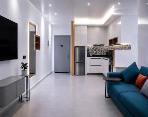 a living room with a blue couch and a kitchen at Résidence Kariat Cabo 2-bedroom apartment in Cabo Negro