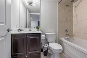 a bathroom with a toilet and a sink and a tub at Mississauga Downtown Condos in Mississauga +209 photos