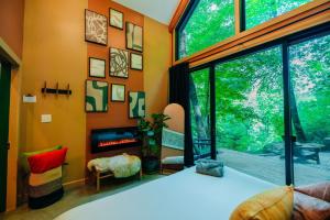 a living room with a fireplace and a large window at The Taoist 5min to Gorge with Private Cliffs in Rogers