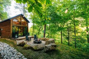 a cabin in the woods with a fire pit and rocks at The Taoist 5min to Gorge with Private Cliffs in Rogers