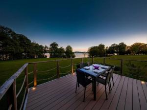 a wooden deck with a table and chairs on it at Lakeside Stay with Sauna in Boussu-lez-Walcourt