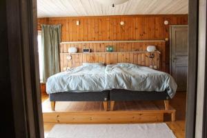 a bedroom with a bed with a wooden wall at GOT121-Laerbro-Rute-Sofiero-133 in Lärbro