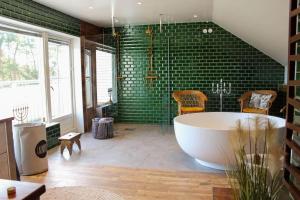 a large bathroom with a tub and green tiles at GOT121-Laerbro-Rute-Sofiero-133 in Lärbro +57 photos