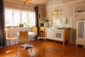 a kitchen with a table and a table and chairs at GOT121-Laerbro-Rute-Sofiero-133 in Lärbro