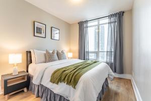 a bedroom with a bed and a large window at Mississauga Downtown Condos in Mississauga