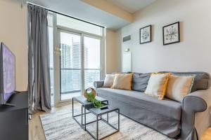 a living room with a couch and a large window at Mississauga Downtown Condos in Mississauga